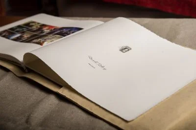 Album photos de mariage relié, pages blanches ouvertes sur fond textile