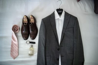 Costume gris, chemise et cravate suspendus avant un mariage au Château de la Beaumetane