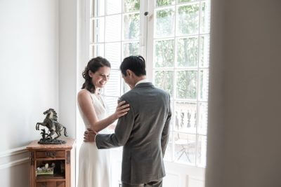 Mariage au Château de la Beaumetane, couple complice devant une fenêtre lumineuse