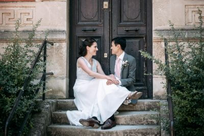Couple de mariés souriant sur les marches en pierre, Château de la Beaumetane