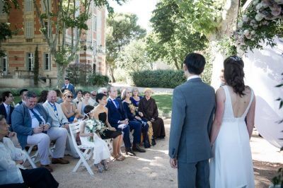 Mariés échangeant leurs voeux devant invités assis, cérémonie extérieure Château de la Beaumetane