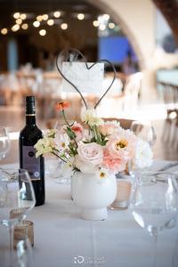 Composition florale pastel et bouteille de vin, décoration mariage Magnanerie Saint Isidore
