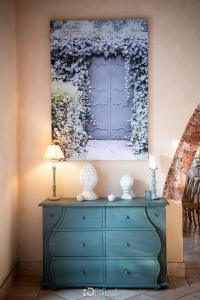 Commode bleue avec vases blancs sous un tableau fleuri, Magnanerie Saint Isidore, Hyères
