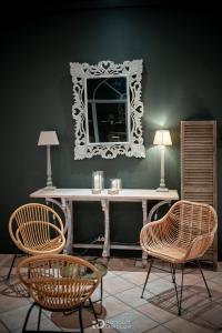 Coin salon avec miroir sculpte, console et fauteuils rotin, Magnanerie Saint Isidore, Hyeres