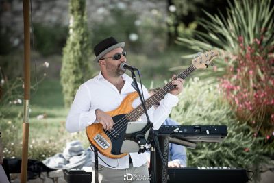 Homme jouant de la basse en exterieur lors d'un mariage au Mas des Costes