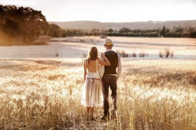 Photographe mariage Marseille : couple enlacé dans un champ au coucher du soleil