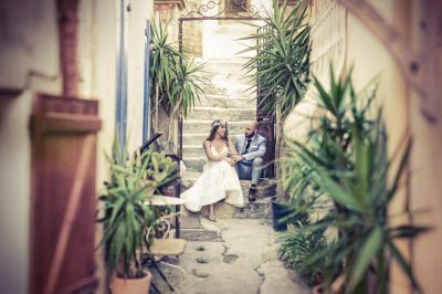 Photographe mariage Marseille : mariée en robe blanche sous une ruelle ornée de plantes