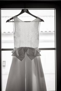 Robe de mariée blanche à nœud suspendue devant une fenêtre, Bastide Saint Julien