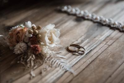 Alliances dorées posées près d'un bouquet champêtre, mariage Bastide Saint Julien