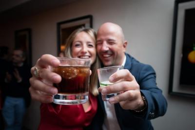 Couple souriant trinquant avec des verres, ambiance mariage Bastide Saint Julien
