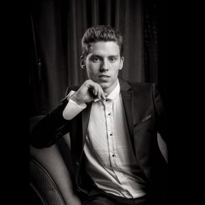 Portrait d'un homme jeune en studio en noir et blanc, éclairage sophistiqué