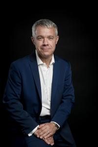 Portrait dirigeant entreprise assis, regard présent, éclairage cinematographique