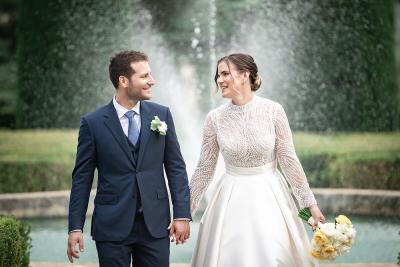 Bride and groom walking hand in hand by a fountain in Provence