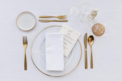 Elegant place setting with gold cutlery and personalised menu