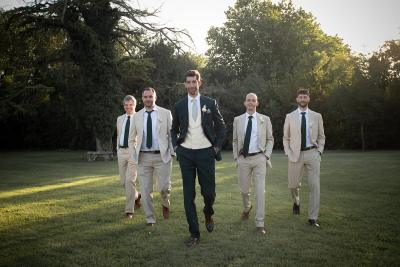 Groom walking with his groomsmen across the château gardens